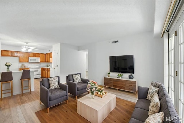 3425 Country Stone Manor Dr Unit G, Valley Park, MO 63088 - living area with light wood-type flooring, ceiling fan, and a textured ceiling