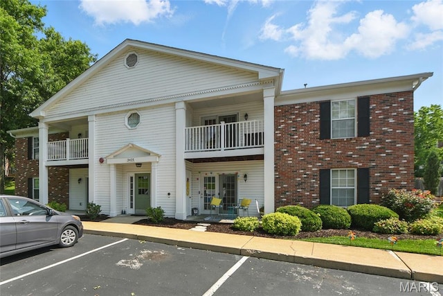 3425 Country Stone Manor Dr Unit G, Valley Park, MO 63088 - view of front of property with a balcony, uncovered parking, brick siding, and covered porch