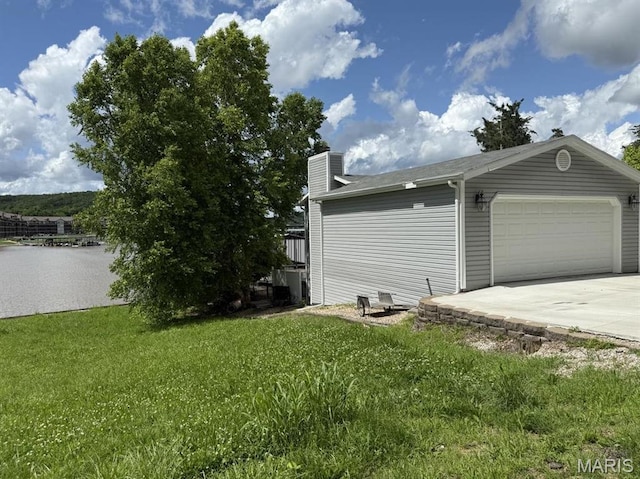 63 Rock Dove Ln, Camdenton, MO 65020 - view of side of property with a lawn, a chimney, concrete driveway, a garage, and cooling unit