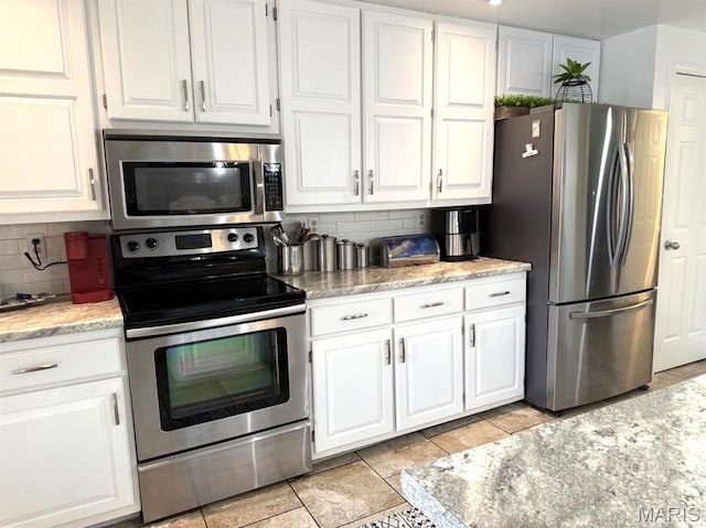 63 Rock Dove Ln, Camdenton, MO 65020 - kitchen featuring stainless steel appliances, decorative backsplash, white cabinets, and light tile patterned floors