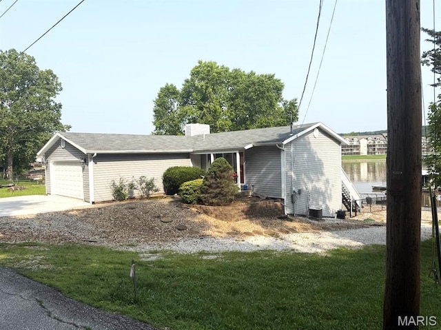 63 Rock Dove Ln, Camdenton, MO 65020 - ranch-style house with a water view, a chimney, concrete driveway, a garage, and a front yard
