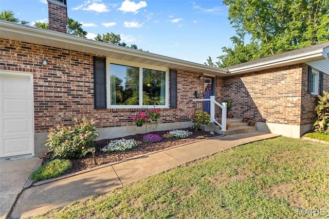 611 Park St, Farmington, MO 63640 - entrance to property with brick siding, a chimney, a yard, and an attached garage