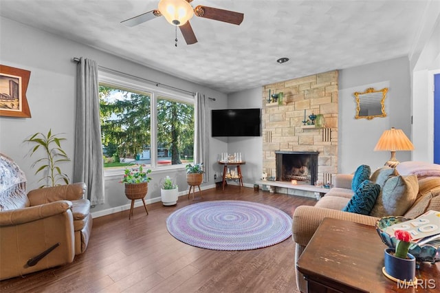 611 Park St, Farmington, MO 63640 - living area featuring ceiling fan, a textured ceiling, wood finished floors, and a stone fireplace