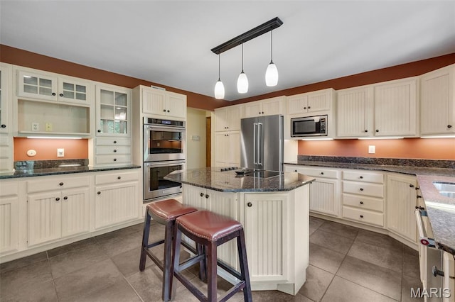 1509 Redbriar Dr, High Ridge, MO 63049 - kitchen featuring stainless steel appliances, a center island, dark stone counters, and dark tile patterned floors
