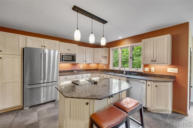 1509 Redbriar Dr, High Ridge, MO 63049 - kitchen with stainless steel appliances, a center island, dark stone counters, a kitchen bar, and pendant lighting