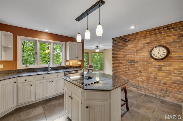 1509 Redbriar Dr, High Ridge, MO 63049 - kitchen with brick wall, black electric stovetop, tile patterned flooring, a kitchen bar, and pendant lighting