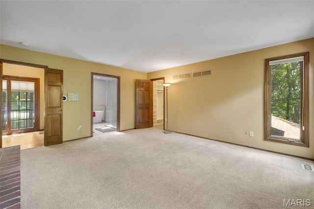 1509 Redbriar Dr, High Ridge, MO 63049 - unfurnished bedroom with multiple windows, light carpet, and connected bathroom