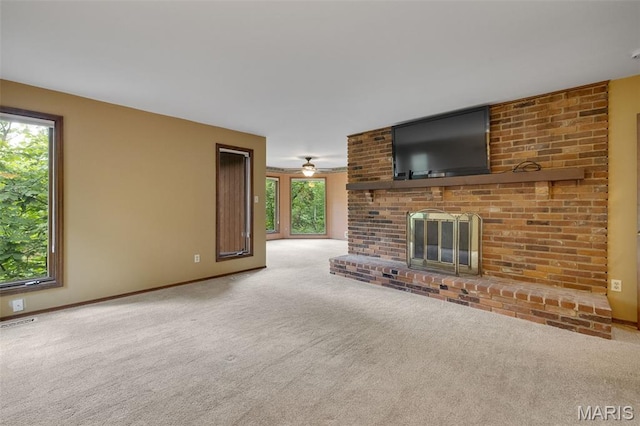 1509 Redbriar Dr, High Ridge, MO 63049 - unfurnished living room featuring healthy amount of natural light, carpet flooring, a brick fireplace, and a ceiling fan