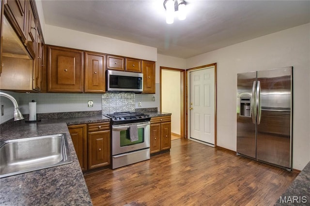 10000 Wondell Woods Dr, Belleville, IL 62223 - kitchen featuring stainless steel appliances, backsplash, dark countertops, dark wood-style flooring, and brown cabinets