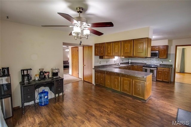 10000 Wondell Woods Dr, Belleville, IL 62223 - kitchen featuring appliances with stainless steel finishes, dark countertops, brown cabinetry, a peninsula, and a ceiling fan