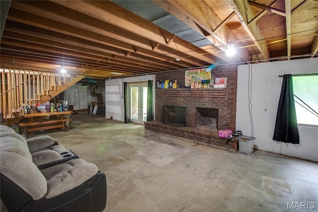 10000 Wondell Woods Dr, Belleville, IL 62223 - living area featuring unfinished concrete flooring, stairs, a brick fireplace, and healthy amount of natural light