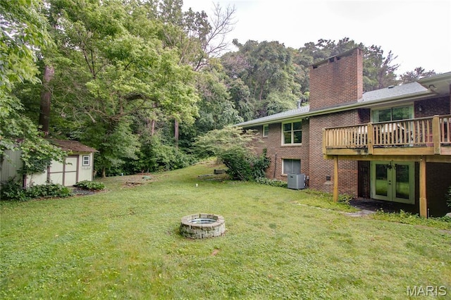10000 Wondell Woods Dr, Belleville, IL 62223 - view of grassy yard with an outdoor fire pit, a storage unit, french doors, and a deck