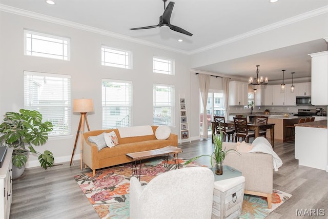 509 Spruce Hollow Ct, Wentzville, MO 63385 - living room with light wood finished floors, ornamental molding, recessed lighting, a ceiling fan, and a chandelier