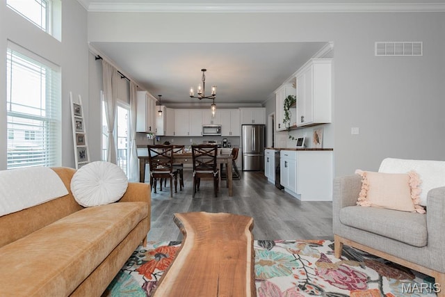 509 Spruce Hollow Ct, Wentzville, MO 63385 - living room with a chandelier, dark wood-type flooring, plenty of natural light, and ornamental molding