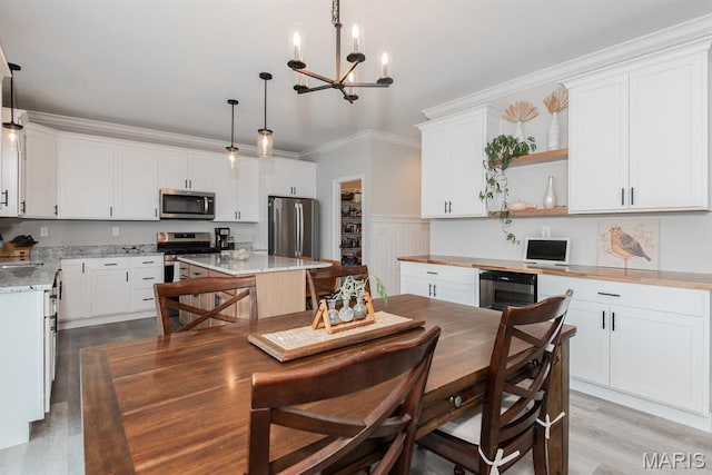 509 Spruce Hollow Ct, Wentzville, MO 63385 - dining area with a chandelier, beverage cooler, light wood-style flooring, ornamental molding, and a wainscoted wall