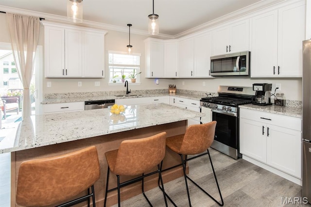 509 Spruce Hollow Ct, Wentzville, MO 63385 - kitchen featuring appliances with stainless steel finishes, a breakfast bar area, ornamental molding, white cabinets, and decorative light fixtures