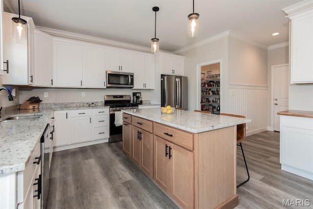 509 Spruce Hollow Ct, Wentzville, MO 63385 - kitchen featuring stainless steel appliances, dark wood finished floors, wainscoting, crown molding, and a center island