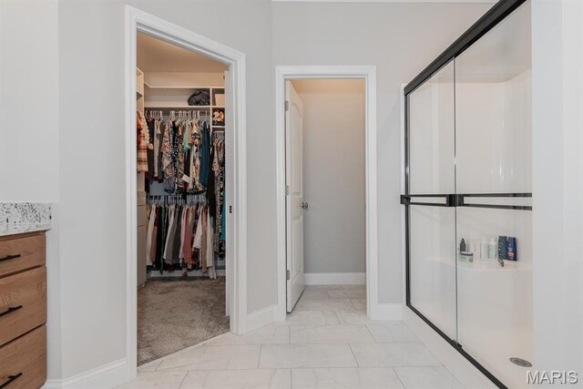 509 Spruce Hollow Ct, Wentzville, MO 63385 - full bath featuring a stall shower, a walk in closet, marble look tile flooring, and vanity