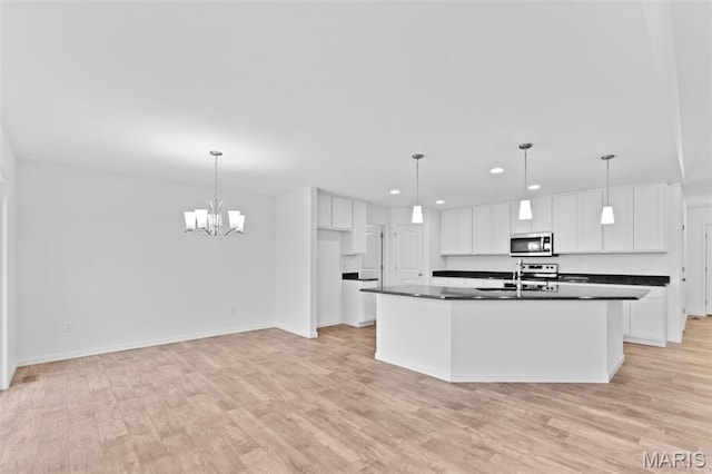 104 Tick Rd, Silex, MO 63377 - kitchen featuring stainless steel microwave, dark countertops, recessed lighting, white cabinetry, and light wood-style floors