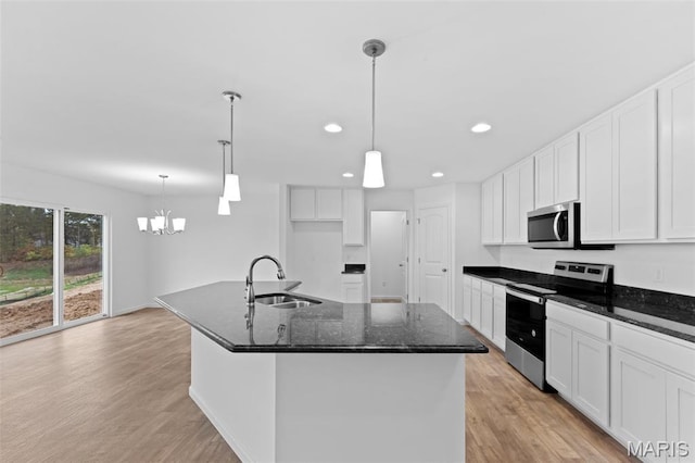 104 Tick Rd, Silex, MO 63377 - kitchen with appliances with stainless steel finishes, a chandelier, light wood finished floors, white cabinetry, and recessed lighting