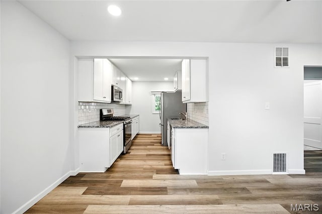 7825 Delmont St, Saint Louis, MO 63123 - kitchen with appliances with stainless steel finishes, light wood-style floors, backsplash, and recessed lighting
