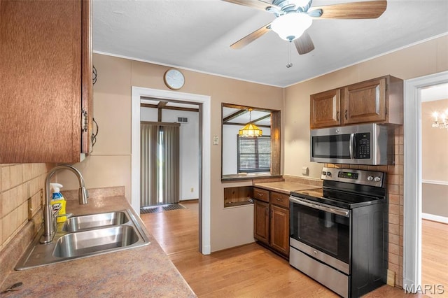 914 Trelane Ave, Crestwood, MO 63126 - kitchen with appliances with stainless steel finishes, light wood finished floors, brown cabinets, and light countertops