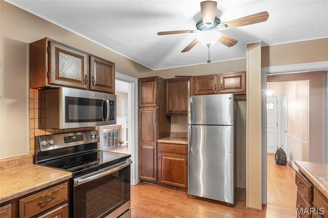 914 Trelane Ave, Crestwood, MO 63126 - kitchen with stainless steel appliances, light countertops, light wood-type flooring, a ceiling fan, and crown molding