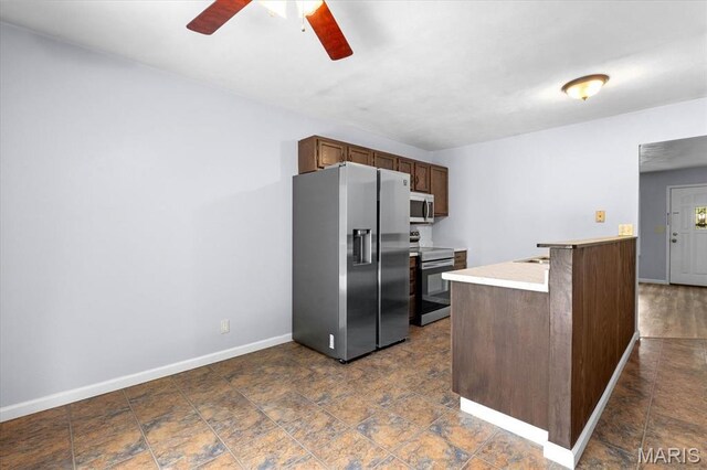 104 Britanna Dr, Swansea, IL 62226 - kitchen featuring appliances with stainless steel finishes, ceiling fan, light countertops, a peninsula, and dark stone finish floors