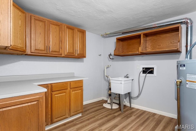 104 Britanna Dr, Swansea, IL 62226 - laundry room with electric water heater, hookup for a washing machine, cabinet space, and light wood-style floors