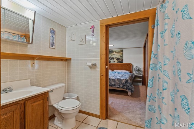 614 Main St, Keyesport, IL 62253 - ensuite bathroom featuring vanity, tile patterned flooring, tile walls, and curtained shower