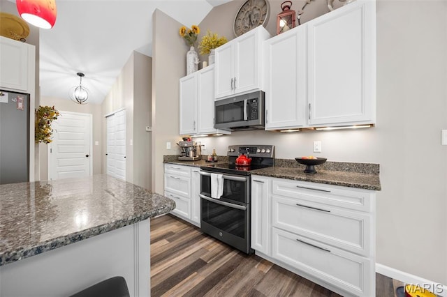 815 Mule Creek Dr, Wentzville, MO 63385 - kitchen featuring appliances with stainless steel finishes, vaulted ceiling, dark wood finished floors, white cabinetry, and dark stone countertops