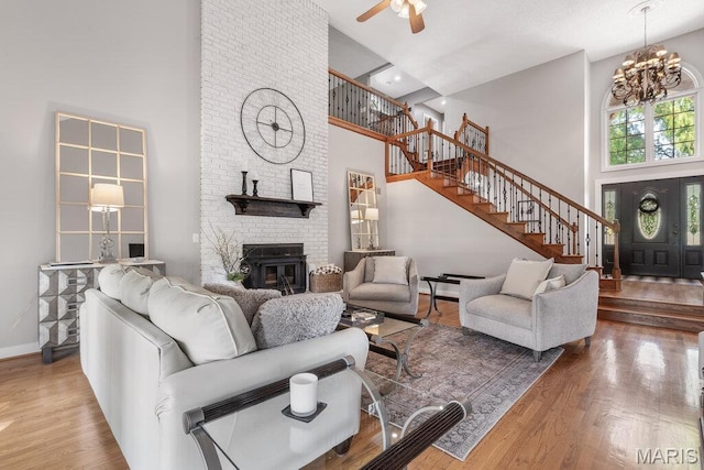 108 Lucys Lndg, Waterloo, IL 62298 - living room featuring a high ceiling, stairway, a fireplace, wood finished floors, and a chandelier