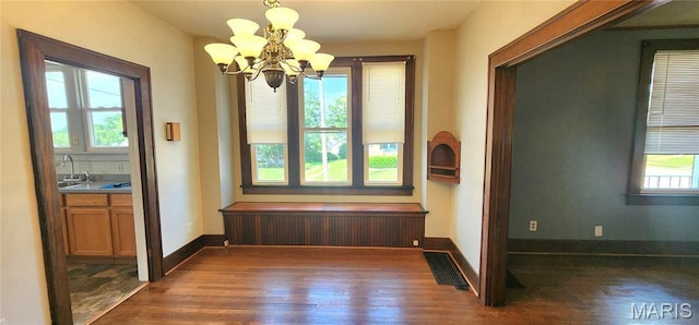 1629 Swanwick St, Chester, IL 62233 - unfurnished dining area with dark wood-style flooring, healthy amount of natural light, a chandelier, and baseboards