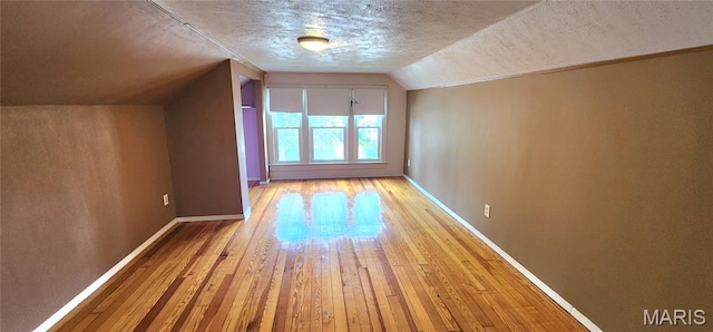 1629 Swanwick St, Chester, IL 62233 - additional living space with a textured ceiling, light wood-style flooring, vaulted ceiling, and baseboards