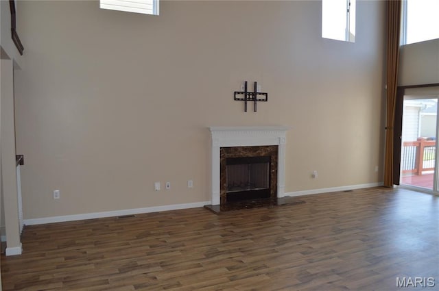 1313 Commons Cir, Cottleville, MO 63304 - unfurnished living room featuring a high ceiling, dark wood-type flooring, and a fireplace