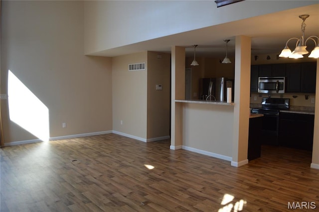 1313 Commons Cir, Cottleville, MO 63304 - kitchen featuring stainless steel appliances, dark wood finished floors, a chandelier, light countertops, and pendant lighting