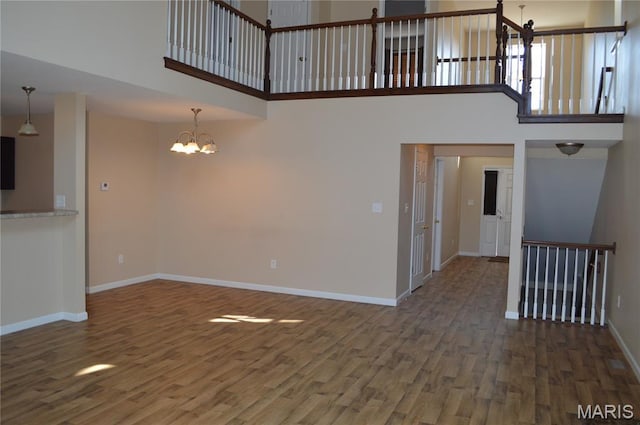 1313 Commons Cir, Cottleville, MO 63304 - unfurnished living room with a chandelier, a high ceiling, and wood finished floors