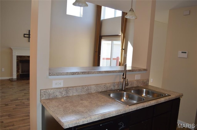 1313 Commons Cir, Cottleville, MO 63304 - kitchen with wood finished floors, dishwashing machine, hanging light fixtures, a premium fireplace, and light countertops