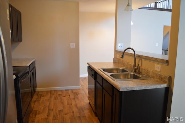 1313 Commons Cir, Cottleville, MO 63304 - kitchen with appliances with stainless steel finishes, light wood-style floors, dark brown cabinetry, and light countertops