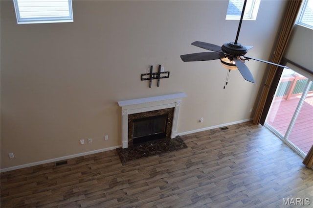 1313 Commons Cir, Cottleville, MO 63304 - unfurnished living room with a ceiling fan, wood finished floors, plenty of natural light, and a high end fireplace