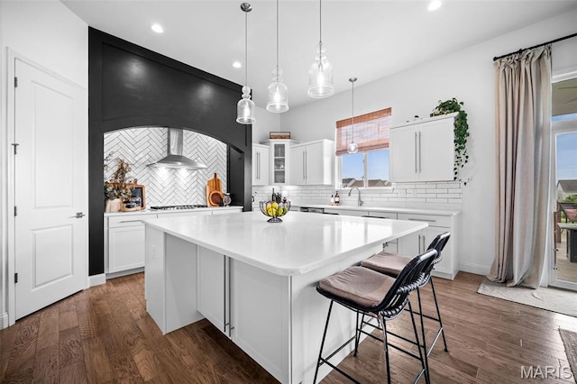 932 Colebrook Ct, Lake St Louis, MO 63367 - kitchen with a kitchen island, backsplash, light countertops, white cabinets, and wall chimney range hood