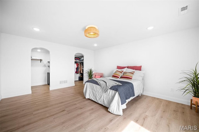 932 Colebrook Ct, Lake St Louis, MO 63367 - bedroom with arched walkways, wood finished floors, a spacious closet, and recessed lighting