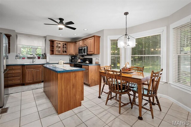 20220 Inverness Dr, Marthasville, MO 63357 - kitchen with black range, stainless steel microwave, a kitchen island, brown cabinetry, and a chandelier