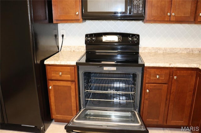 12574 Chardin Pl Unit 1, Tesson Ferry Township, MO 63128 - kitchen featuring black appliances, tasteful backsplash, and brown cabinetry