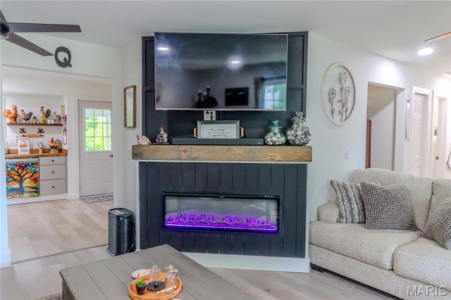 1304 Highland Dr, Rolla, MO 65401 - living area with a glass covered fireplace, wood finished floors, and a ceiling fan