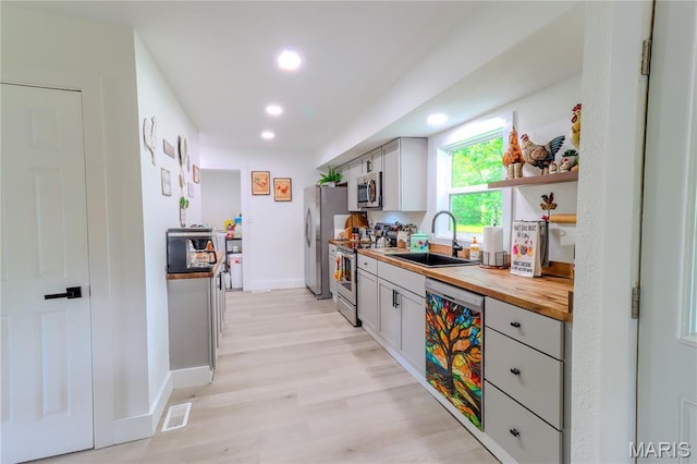 1304 Highland Dr, Rolla, MO 65401 - kitchen with appliances with stainless steel finishes, butcher block counters, recessed lighting, and light wood-style floors