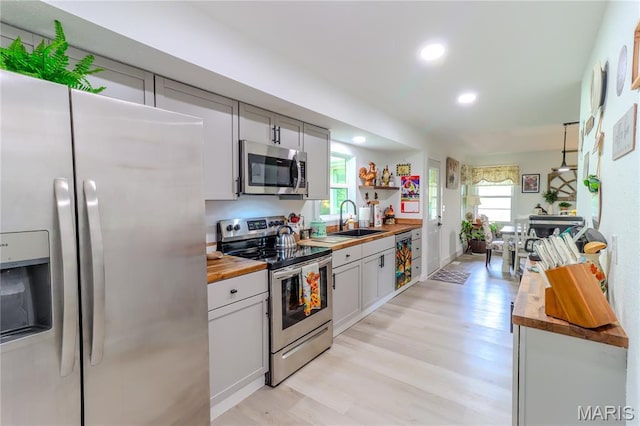1304 Highland Dr, Rolla, MO 65401 - kitchen featuring appliances with stainless steel finishes, butcher block counters, light wood-style flooring, recessed lighting, and open shelves