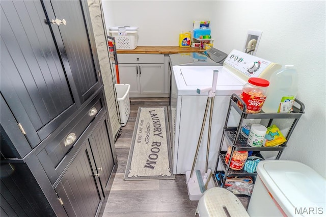 1304 Highland Dr, Rolla, MO 65401 - washroom with washer and clothes dryer, wood finished floors, and cabinet space