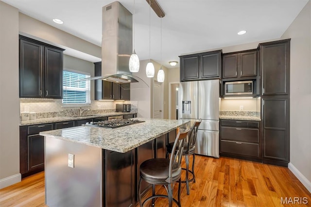 306 Essen Ln, Ballwin, MO 63021 - kitchen with stainless steel appliances, island exhaust hood, light wood-style floors, a kitchen island, and recessed lighting
