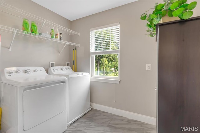 306 Essen Ln, Ballwin, MO 63021 - laundry room with washer and clothes dryer, light marble finish flooring, and plenty of natural light